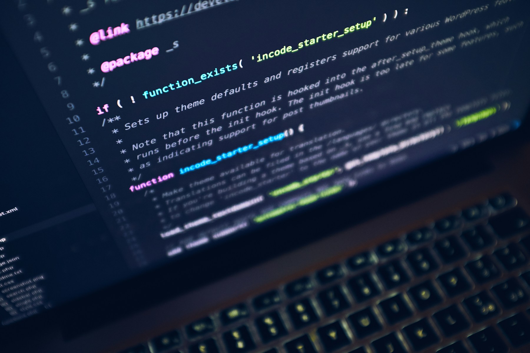 A laptop keyboard and a screen displaying source code